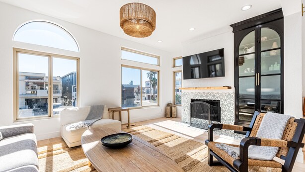 A spacious living room with large windows, a fireplace, and a modern design. - STUNNING! Ocean Views!! Lux Remodeled Modern Beach House. +PELETON . (Oxnard)