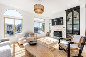 Un salón amplio con ventanas grandes, una chimenea y un diseño moderno.