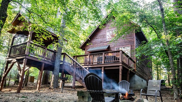 A cabin with a deck and a fire pit area.