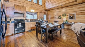 A wooden cabin interior with a kitchen, dining area, and a cozy seating space. - Journeys End -2 BR-Timber Creek Trails (Broken Bow)