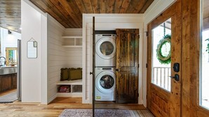 A laundry room with two washing machines, a wooden door, and a view of the outside. - Ravenswood -2 BR+loft-Eagle Mountain East (Broken Bow)