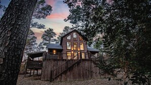 A rustic cabin with a wooden exterior, a covered porch, and a staircase leading to the main entrance. - Ravenswood -2 BR+loft-Eagle Mountain East (Broken Bow)