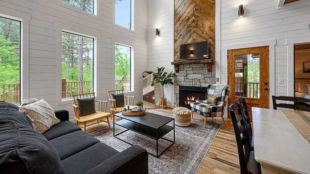 A spacious living room with a fireplace, large windows, and a cozy seating area. - Ravenswood -2 BR+loft-Eagle Mountain East (Broken Bow)