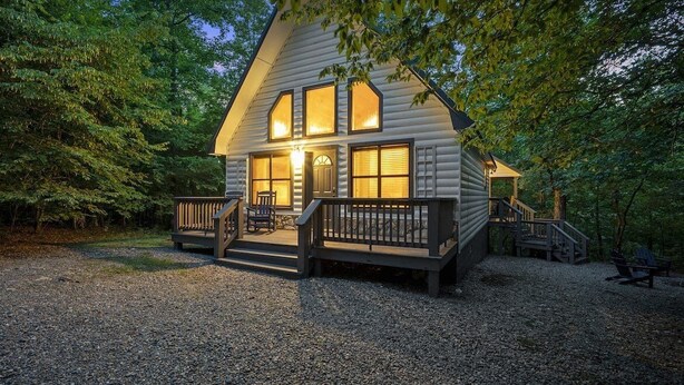 A cabin with a porch, a staircase, and a gravel driveway surrounded by trees. - Summer Brook Studio-Creekside-Timber Creek Trails (Broken Bow)