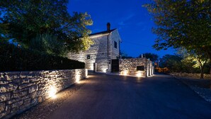 Un edificio de piedra con un camino empedrado que conduce a una entrada porticada.