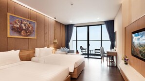 A hotel room with two beds, a desk, and a balcony with a view. - Virgo Hotel (Nha Trang)