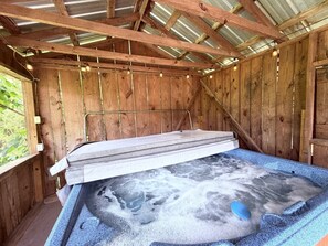 A hot tub with a wooden interior and a metal roof.