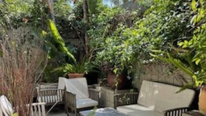 An outdoor patio area with a sofa, chairs, and a coffee table.