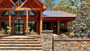 Un chalet avec une façade en bois et une entrée en pierre, portant l’inscription « Parc safari de Beavers Bend ».