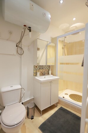 Ein Badezimmer mit Toilette, Waschbecken und Duschbereich.