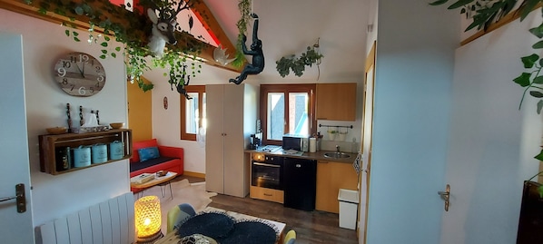 A compact living space with a kitchen, a dining area, and a living room.