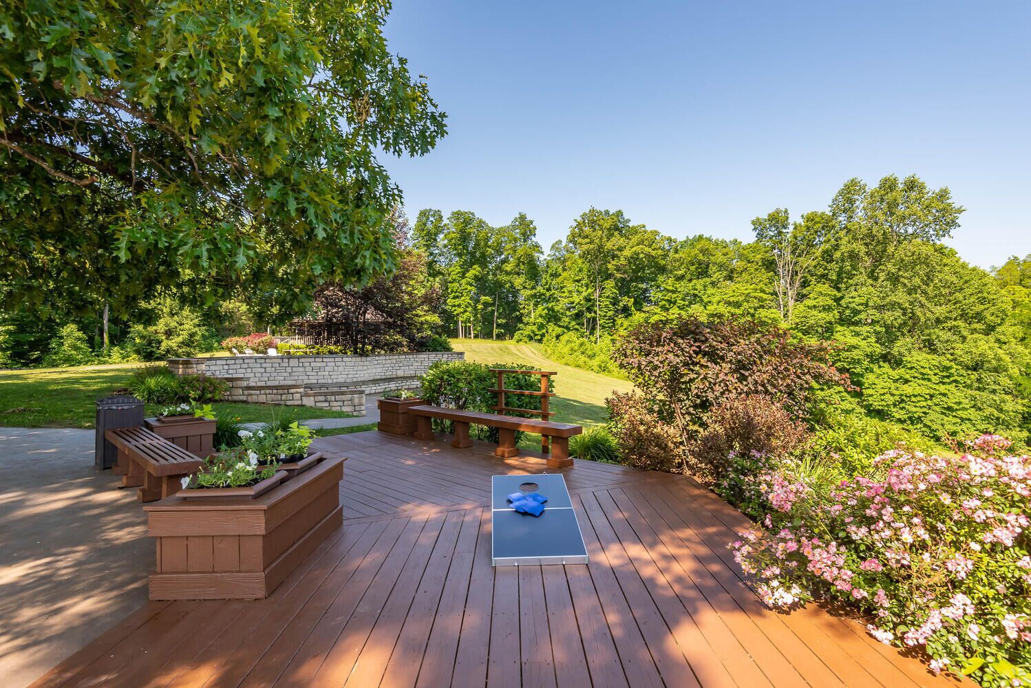 A wooden deck with built-in planters, a bench, and a yoga mat.