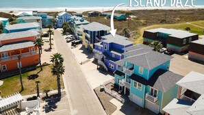 Uma área residencial costeira com casas coloridas, uma praia e céu claro.