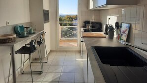 Una cocina moderna con un ventanal grande, un lavamanos y una estufa.