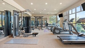 A gym with various exercise equipment, including treadmills, weight machines, and free weights. - Dreamy 2-bedroom condo with sweeping desert views (Hurricane)