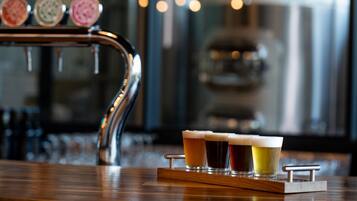 A bar area with a tap and glasses of beer on a wooden tray.