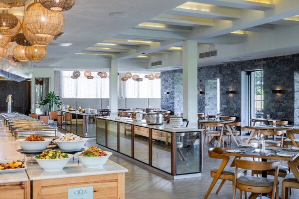 A modern dining area with a buffet setup, wooden furniture, and a stone accent wall.