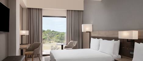A hotel room with two beds, a TV, a desk, and a chair.