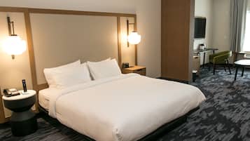 Une chambre d’hôtel avec un grand lit, des tables de chevet, un bureau et une chaise.