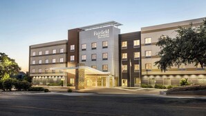 Un hôtel Fairfield by Marriott Inn & Suites au design moderne, avec une entrée imposante dotée d’un auvent et d’un parking situé à l’avant.