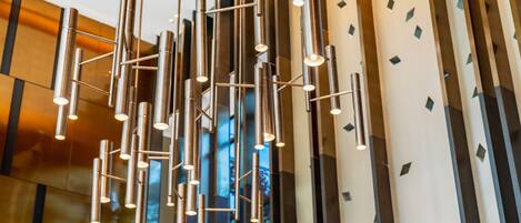 A modern interior with a contemporary light fixture and a patterned wall.