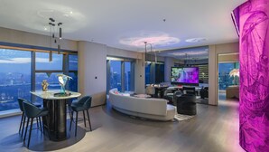 A modern living room with a large window, a round dining table, and a sofa. - W Xiamen (Xiamen)