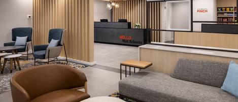 Un área de recepción moderna con mostrador, asientos y una kitchenette.