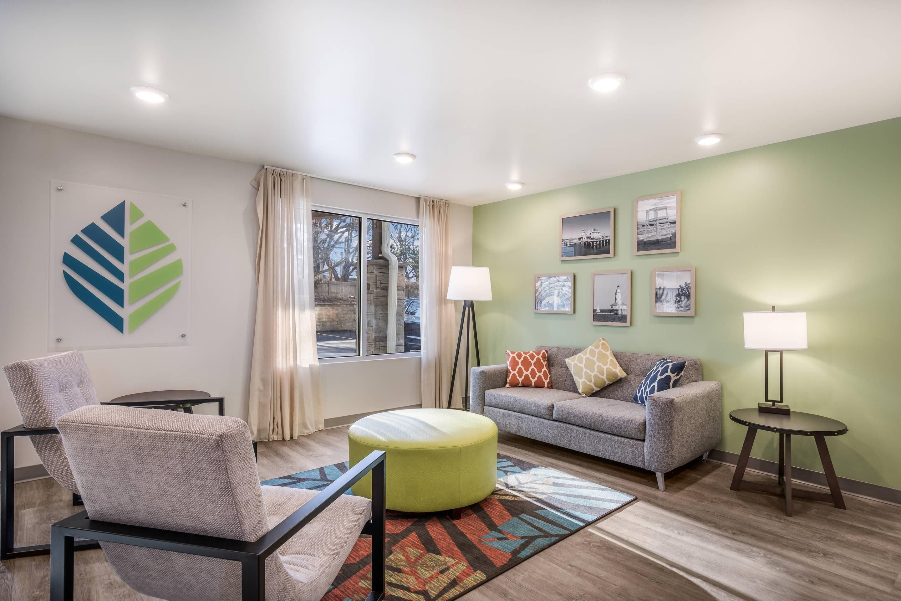 A modern living room with a sofa, chairs, a coffee table, and a floor lamp.