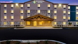 A multi-story hotel with a stone facade and a central entrance. - WoodSpring Suites Gurnee - Chicago (Gurnee)