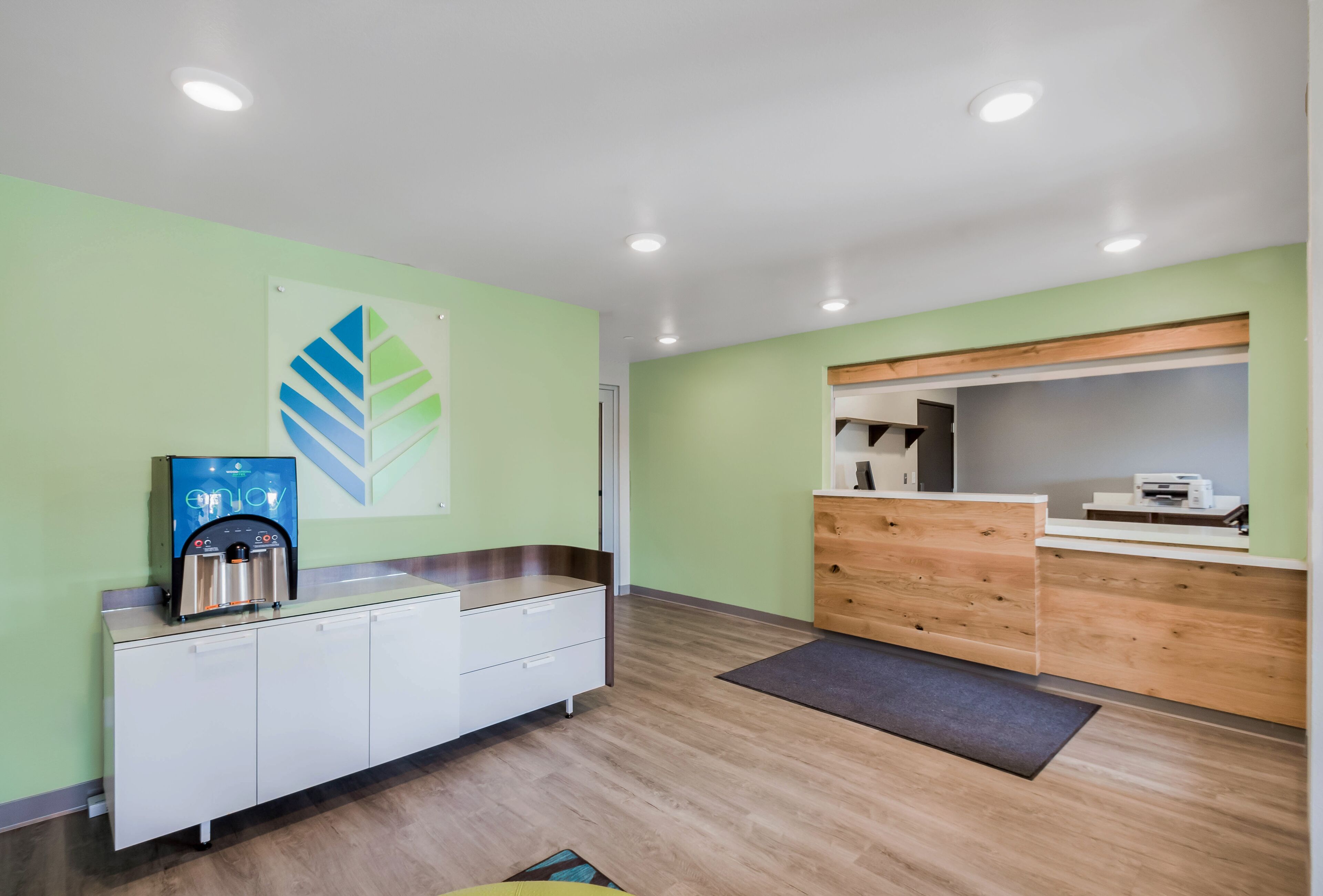 A reception area with a water dispenser, a wooden counter, and a reception desk.