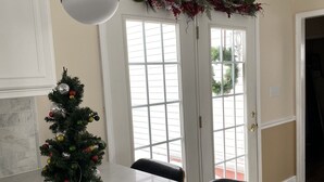 A kitchen with a marble countertop, a small Christmas tree, and two pendant lights.