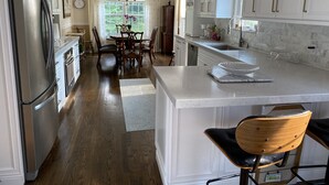 A modern kitchen with white cabinetry, stainless steel appliances, and a central island.