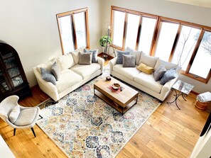 Ein geräumiges Wohnzimmer mit zwei Sofas, einem Couchtisch und einem gemusterten Teppich.