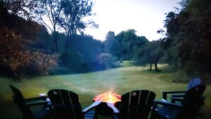 An outdoor seating area with chairs facing a fire pit. - Spacious Fly Creek Retreat – Game Rm, Creek Views & Minutes to Cooperstown & DP (Fly Creek)