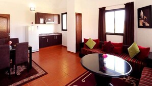 Una sala de estar con sofá, una mesa de comedor y una zona de cocina.