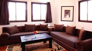 Ein Wohnzimmer mit zwei Sofas, einem Couchtisch und einem gerahmten Bild an der Wand.