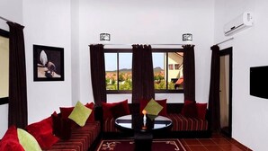 Ein Wohnzimmer mit einer Couch, einem Couchtisch und Blick ins Freie.