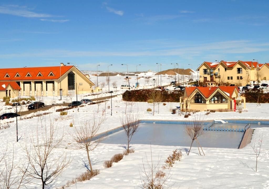A residential area with houses, a swimming pool, and a clear sky.