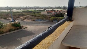 A view from a balcony overlooking a road with a building in the distance. - Residence Les Jardins de La Lagune 2275 (Oualidia)