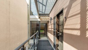A narrow indoor corridor with a metal railing, a glass ceiling, and a door at the end. - Suite Premium Increíble! A 2 Minutos DEL Tec! S06 (Ciudad López Mateos)