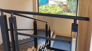 A modern staircase with black railings and a view of greenery outside. - Suite Premium Increíble! A 2 Minutos DEL Tec! S06 (Ciudad López Mateos)