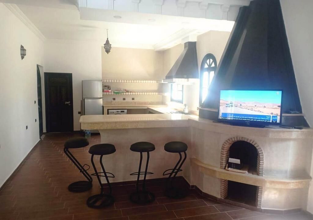 Een koelkast, een oven, een kookplaat, kookgerei, borden en bestek