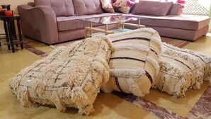 A living room with a sofa, a glass coffee table, and a decorative rug. - Superb apartment in Marrakech 4582 (Marrakech)