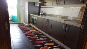 A kitchen with dark cabinets, a stainless steel refrigerator, and a tiled backsplash. - Superb apartment in Marrakech 4582 (Marrakech)