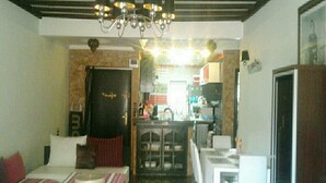 Une chambre d’hôtel compacte comprenant un lit, une petite table à manger, une kitchenette et une salle de bain séparée.
