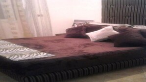 Un lit avec une tête de lit à rayures, une couvre-lit à motifs et plusieurs coussins.