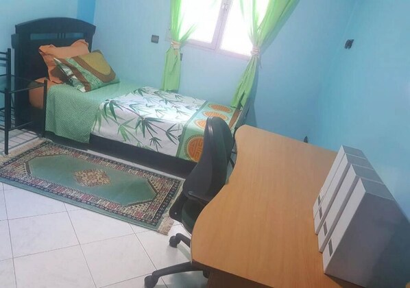 Une chambre à coucher avec un lit, un bureau et une chaise.