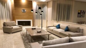A modern living room with a fireplace, two sofas, a coffee table, and a floor lamp. - High standing villa in Marrakech 4614 (Marrakech)