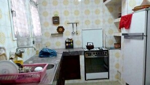 Eine kleine Küche mit Gaskochfeld, Backofen und Kühlschrank.