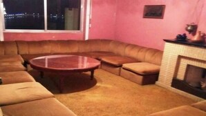 Ein Wohnzimmer mit einem braunen Ledersofa, einem runden Couchtisch und einem Kamin.